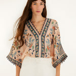 Front view of a model styling the soft pink Farm Rio floral tapestry bodysuit.