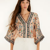 Front view of a model styling the soft pink Farm Rio floral tapestry bodysuit.