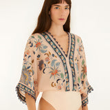 Studio view of the Farm Rio soft pink floral bodysuit highlighting the fit and bottom cut.