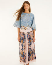 Model wearing Farm Rio soft pink pleated maxi skirt with sea-inspired scarf print, front view