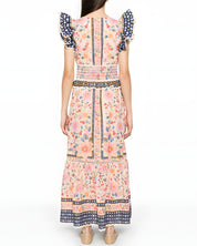 Full-length back studio view of the Farm Rio maxi dress, highlighting the continuous floral pattern, smocked waist detailing, and ruffled shoulders.