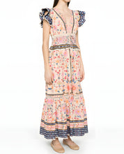 Three-quarter studio view of a model wearing the Farm Rio tapestry printed maxi dress, displaying the elegant drape and tiered skirt layout.