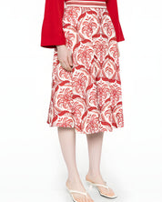 Side studio view of a model wearing the Farm Rio red and white tropical printed midi skirt, paired with a red long-sleeve top.