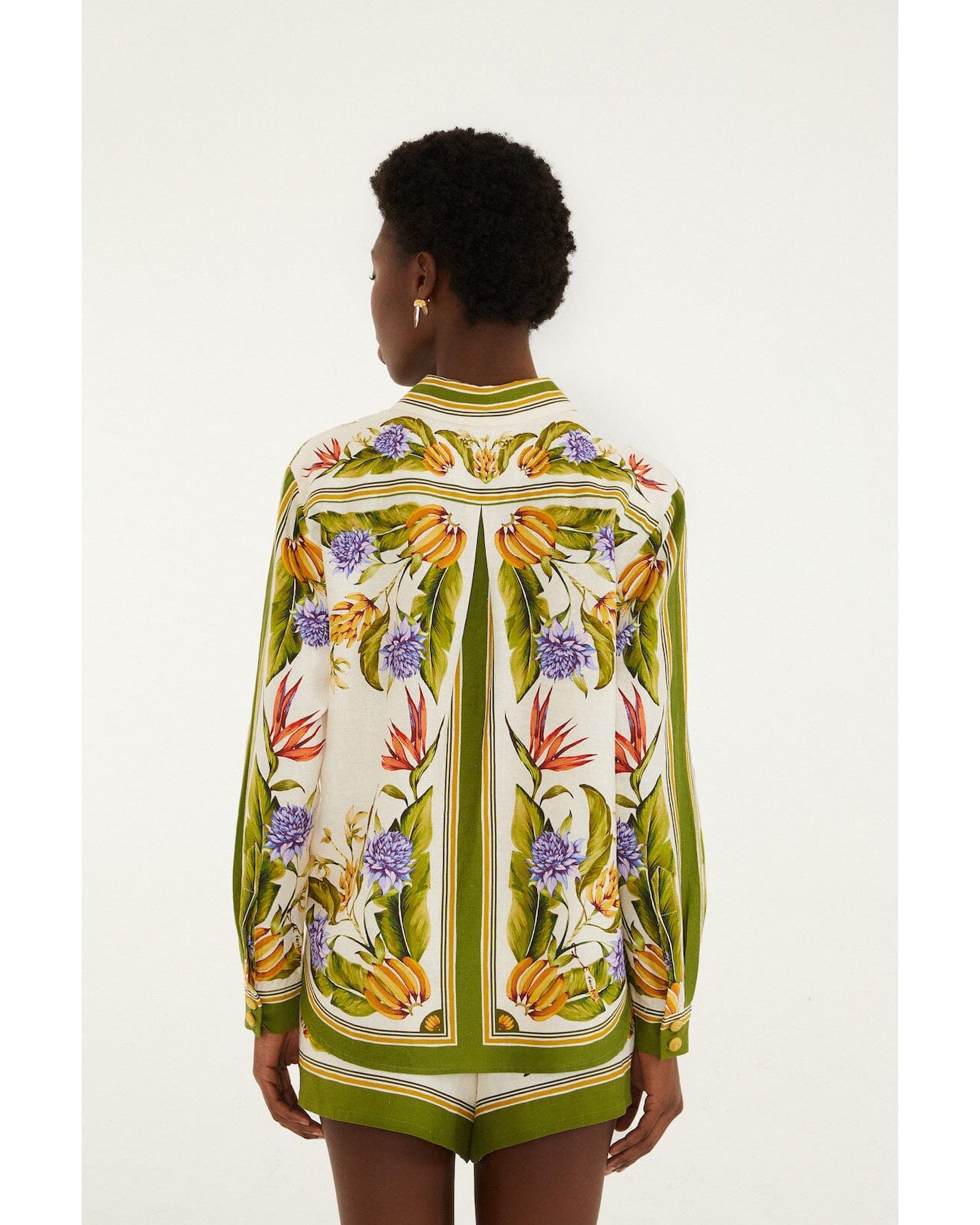Woman wearing a colorful floral patterned shirt on a white background