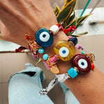 Detailed view of the 24k gold-plated hardware and glass eye on a Goupi textile bracelet.