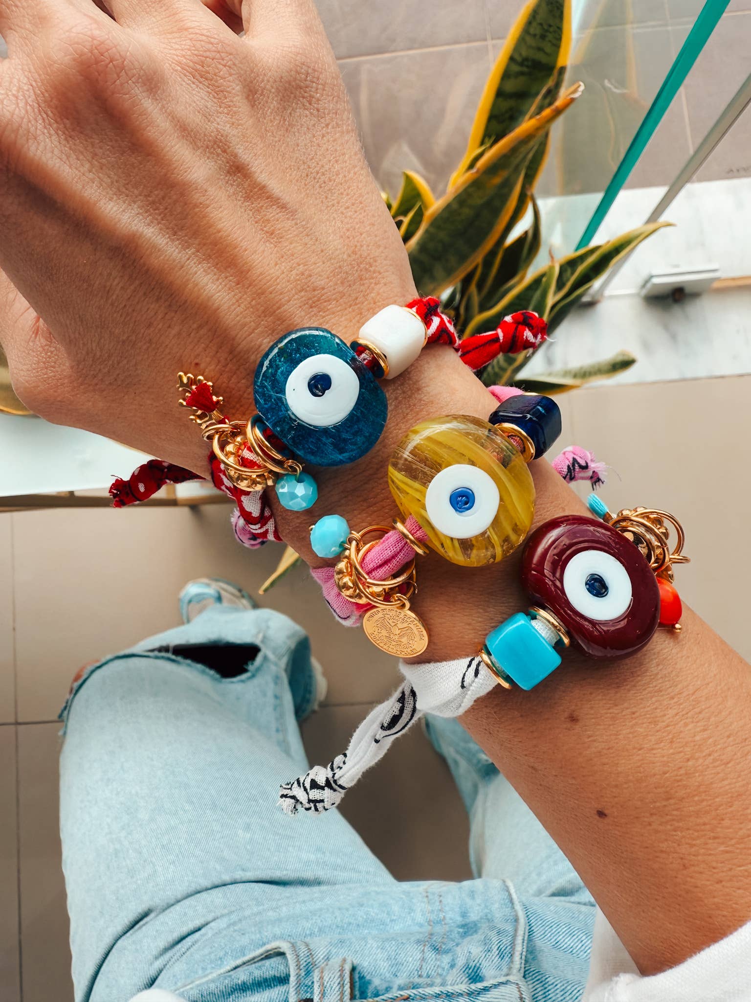 Detailed view of the 24k gold-plated hardware and glass eye on a Goupi textile bracelet.
