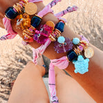 The GOUPI pink lilac crab bracelet styled in a bohemian summer jewelry stack.