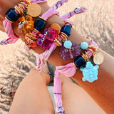 The GOUPI pink lilac crab bracelet styled in a bohemian summer jewelry stack.