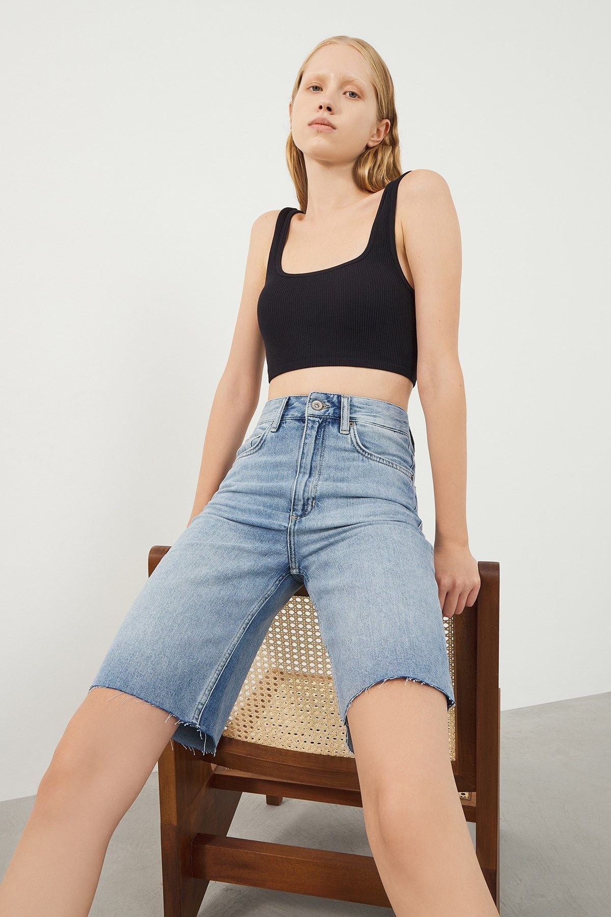 Woman wearing Vera Light Blue Denim Bermuda Shorts, front view