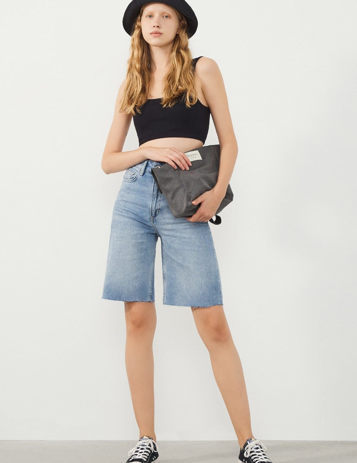 Vera Light Blue Denim Bermuda Shorts styled with a black hat and bag and Sneakers for a modern festival-ready look