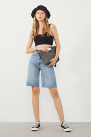 Vera Light Blue Denim Bermuda Shorts styled with a black hat and bag and Sneakers for a modern festival-ready look