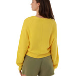 Rear three-quarter view of the yellow summer pullover, highlighting the relaxed oversize fit, seamless shoulder construction, and dropped balloon sleeves.