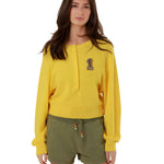 Full-length front view of a model styling the yellow fine knit pullover with casual olive green drawstring shorts.