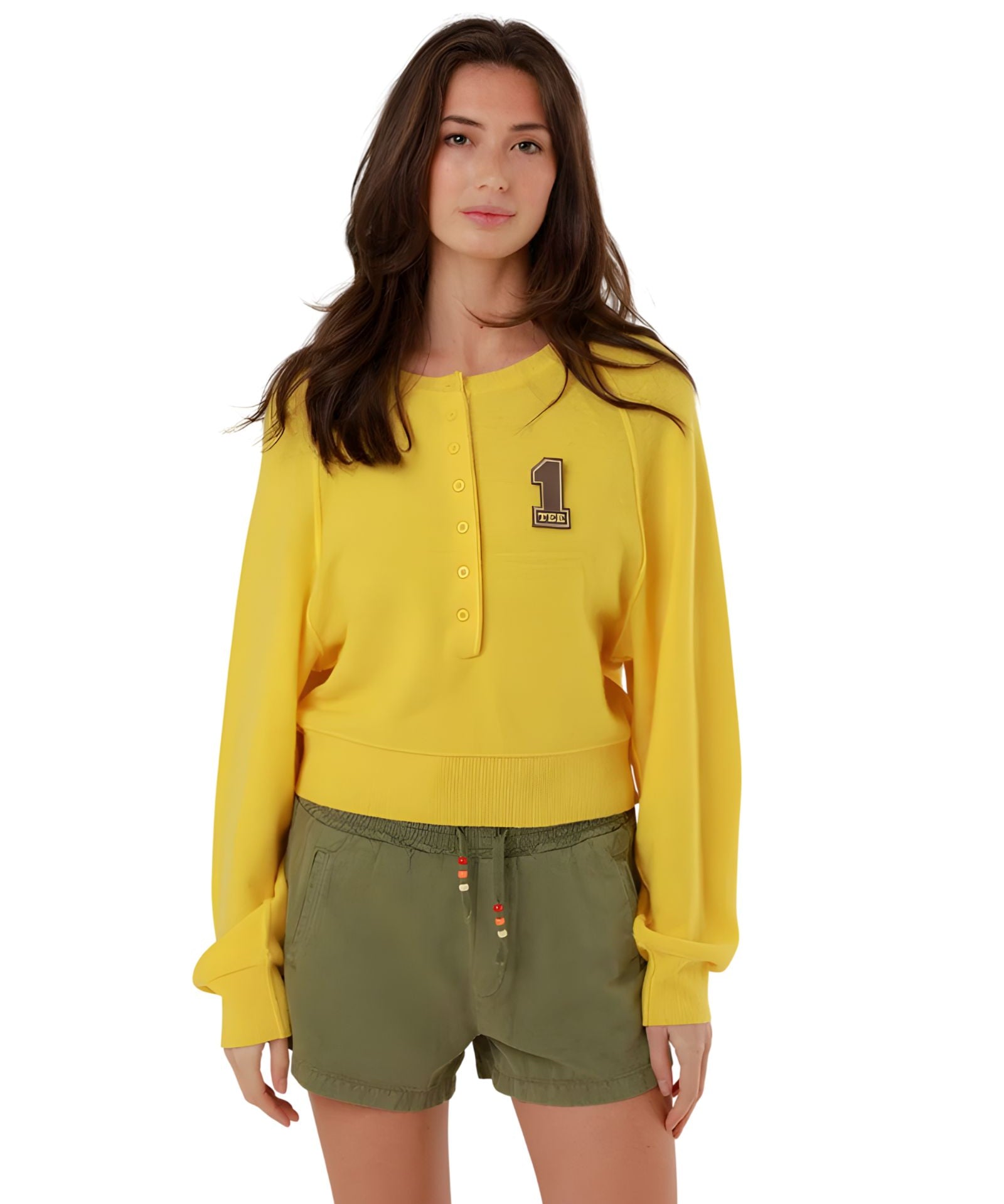 Full-length front view of a model styling the yellow fine knit pullover with casual olive green drawstring shorts.