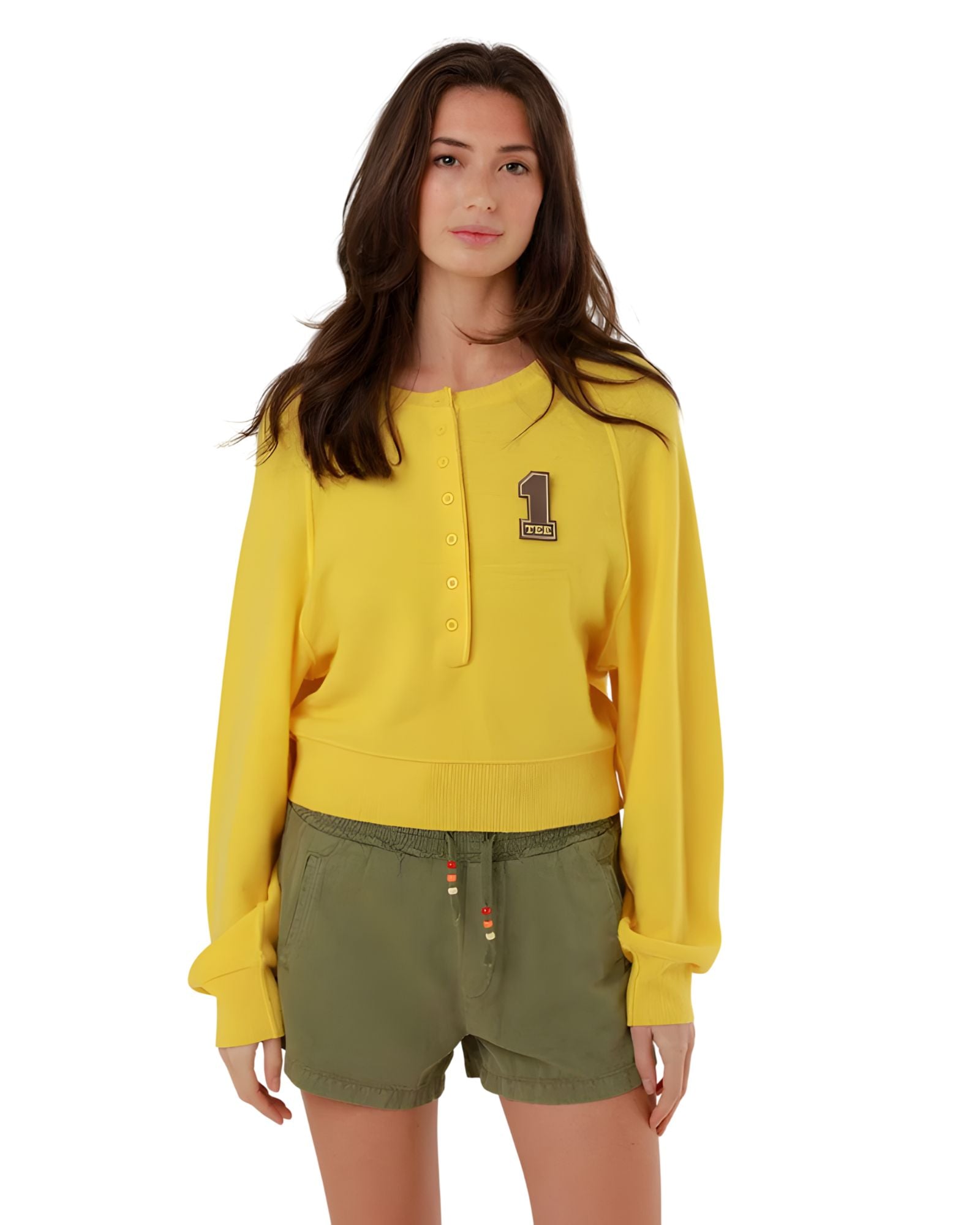 Full-length front view of a model styling the yellow fine knit pullover with casual olive green drawstring shorts.