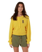 Full-length front view of a model styling the yellow fine knit pullover with casual olive green drawstring shorts.