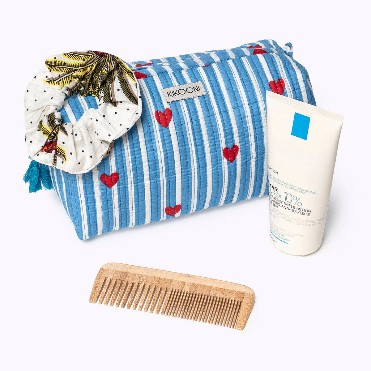 KIKOONI Love Edition blue cosmetic bag styled with skincare and a wooden comb