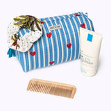 KIKOONI Love Edition blue cosmetic bag styled with skincare and a wooden comb