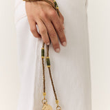 La Coque Française Izzie sage green phone chain worn crossbody with a white outfit