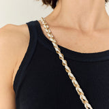La Coque Française Lou braided phone chain in white and gold worn over a black top