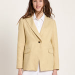 Woman wearing the relaxed-fit LANIUS khaki-creme linen blazer over a white shirt on a plain background