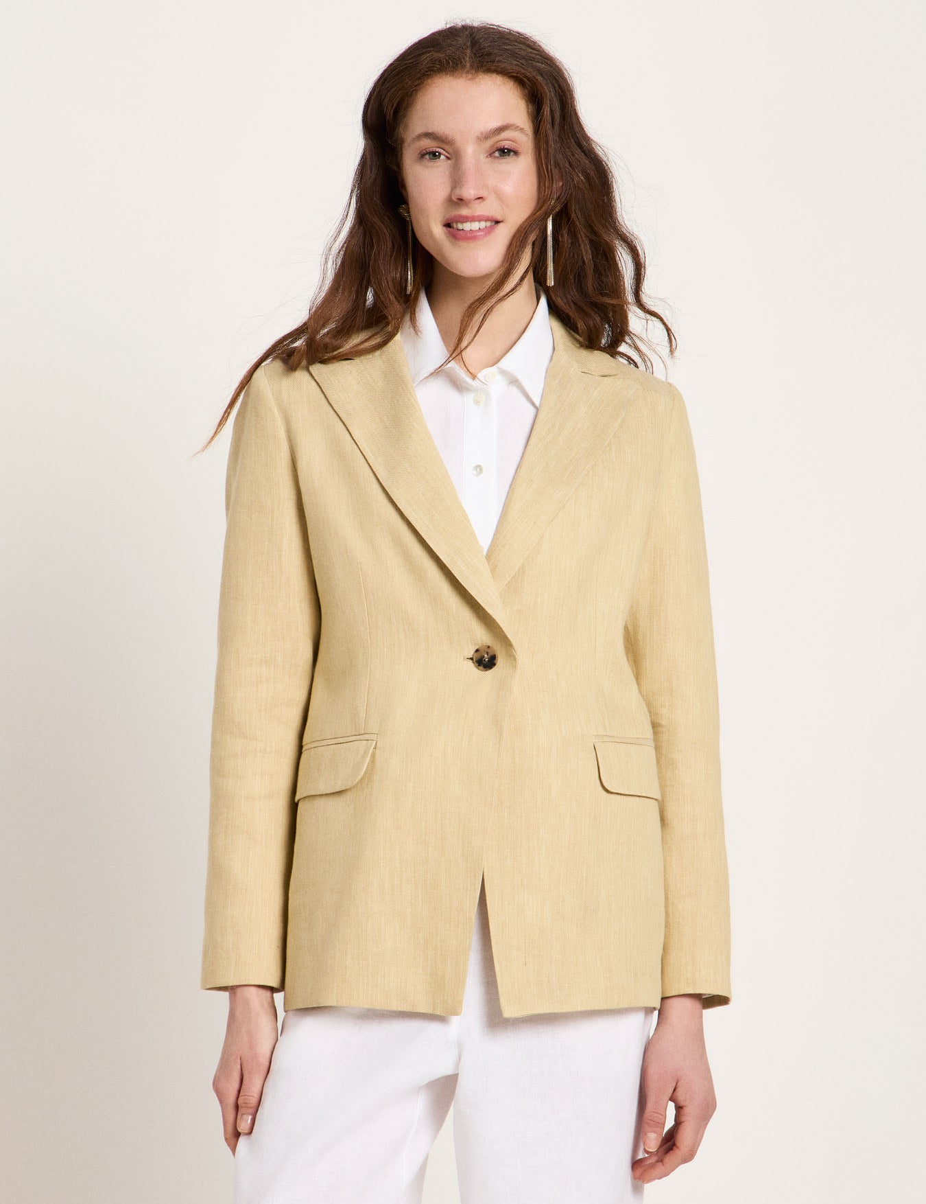 Woman wearing the relaxed-fit LANIUS khaki-creme linen blazer over a white shirt on a plain background
