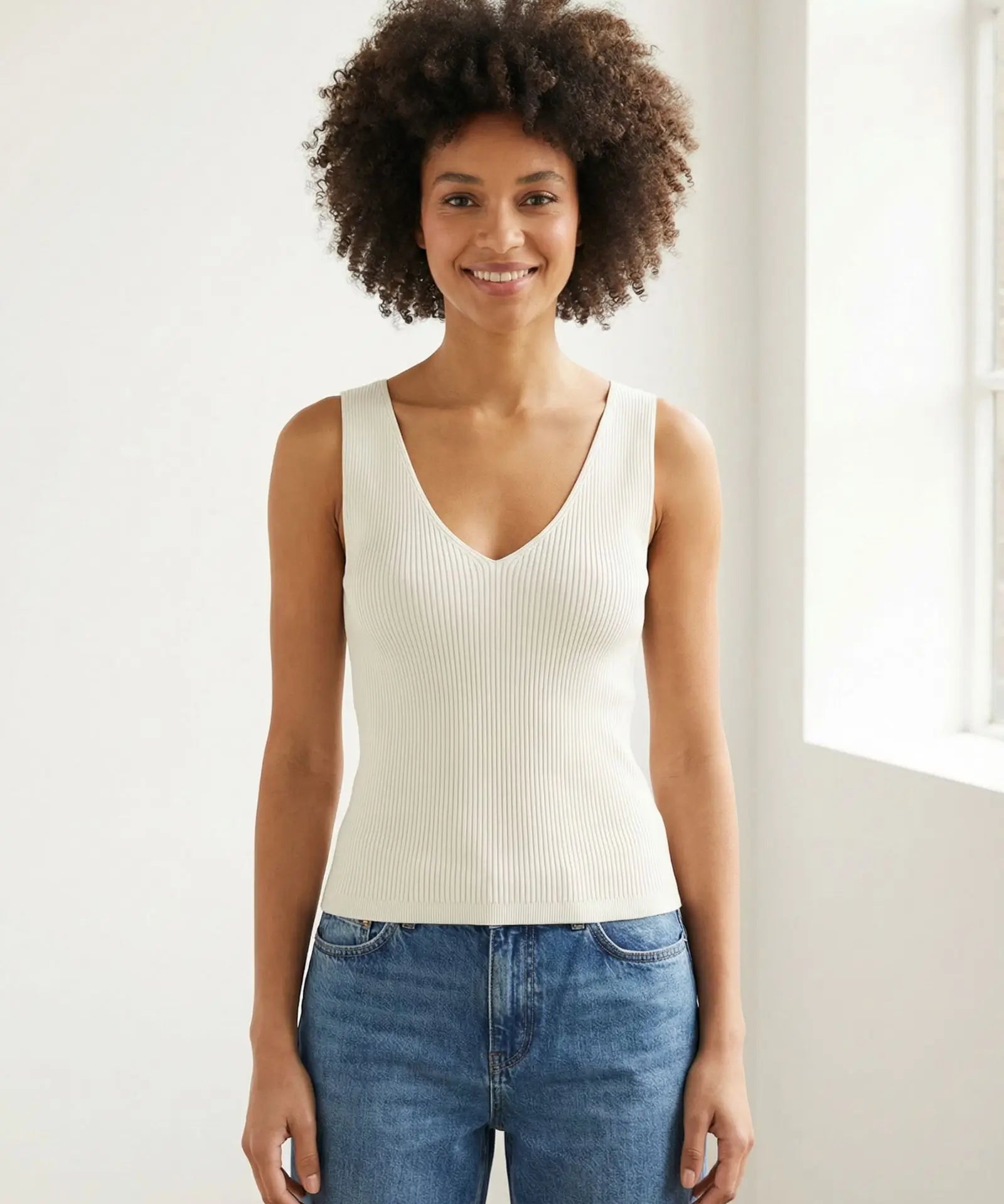 Model wearing a Lanius off-white rib knit organic cotton tank top with a V-neck, styled with blue jeans.
