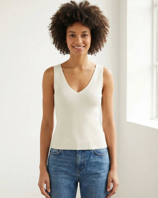 Model wearing a Lanius off-white rib knit organic cotton tank top with a V-neck, styled with blue jeans.