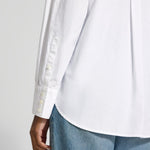 Close-up of the Lanius oversized white shirt showing the sporty button cuffs and the high-quality rounded hem finish