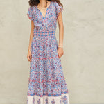 Woman wearing Mabe Apparel Della cotton maxi dress in blue and pink floral print with flutter sleeves.