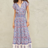 Woman wearing Mabe Apparel Della cotton maxi dress in blue and pink floral print with flutter sleeves.