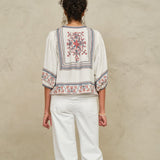 Rear view of a model showcasing the detailed geometric back embroidery on a Mabe Apparel ecru jacket.