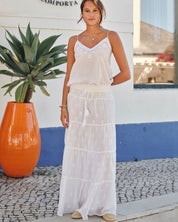 Model outdoors wearing a white embroidered Mabe Apparel camisole and white maxi skirt.