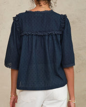 Back view of a woman wearing the Mabe Apparel navy blue embroidered blouse with wide sleeves.