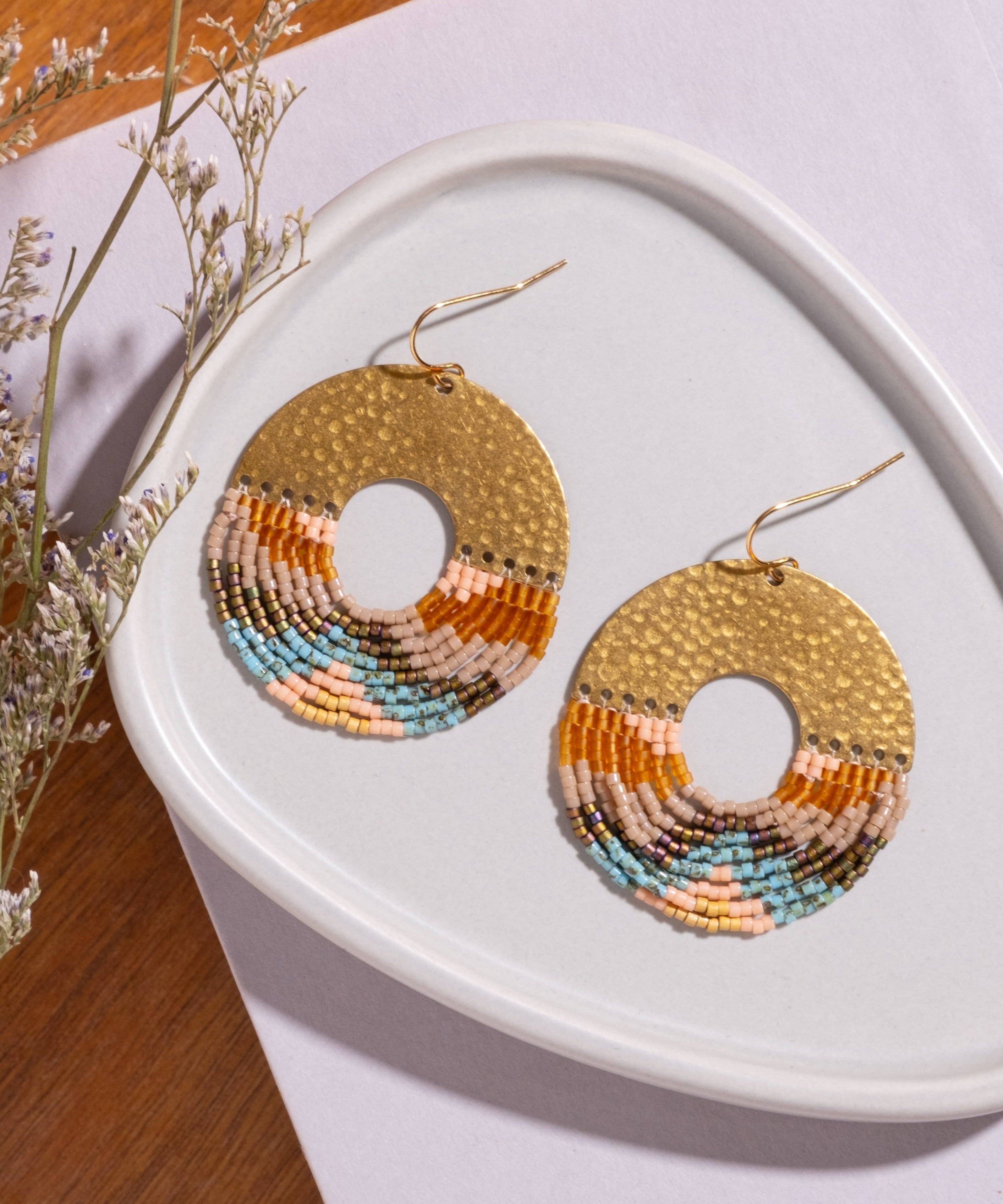 Close-up of Mayana Designs Earth fringe earrings, ombre Miyuki beads and hammered brass arch