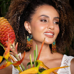 Woman wearing Mayana Designs Beaded Handwoven Jaguar Fringe Earrings, styled with a casual boho-chic outfit.