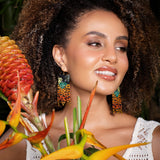 Woman wearing Mayana Designs Beaded Handwoven Jaguar Fringe Earrings, styled with a casual boho-chic outfit.