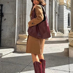 Woman wearing MICUIR Mestizo burgundy cowboy boots with a camel coat dress