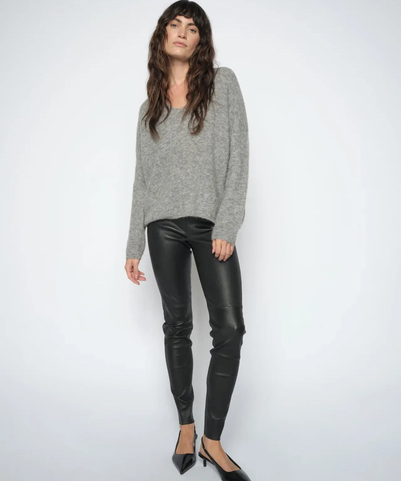 Woman wearing the  Mos Mosh MMSarina black leather leggings styled with a grey knit and black pointed heels.