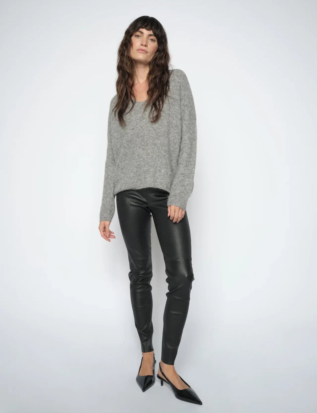 Woman wearing the  Mos Mosh MMSarina black leather leggings styled with a grey knit and black pointed heels.