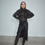 MOS MOSH Vela leather wrap skirt in black with a sculpted metal buckle, worn by a model, front view