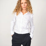 Woman wearing the slim-fit white MMTilda shirt and dark pants for  a polished office look, 