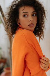 Close-up of the super soft 100% cashmere sweater texture and rich Arancia orange hue