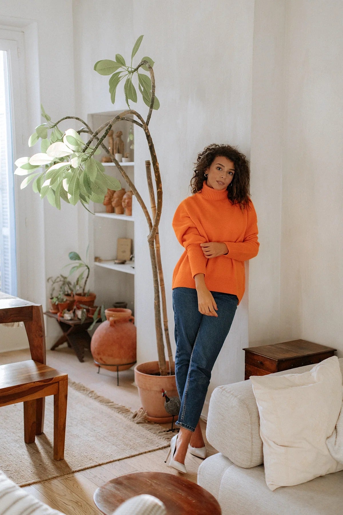 Full-length view of the Arancia orange cashmere sweater styled with denim for an easy, understated look.