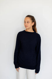 Woman wearing the navy cashmere and silk sweater by Swiss brand Nuage Cashmere.