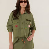 A woman wearing the high-waisted khaki Paul relaxed fit shorts, highlighting the wide-leg cut, side pockets, and bohemian beaded drawstring details.