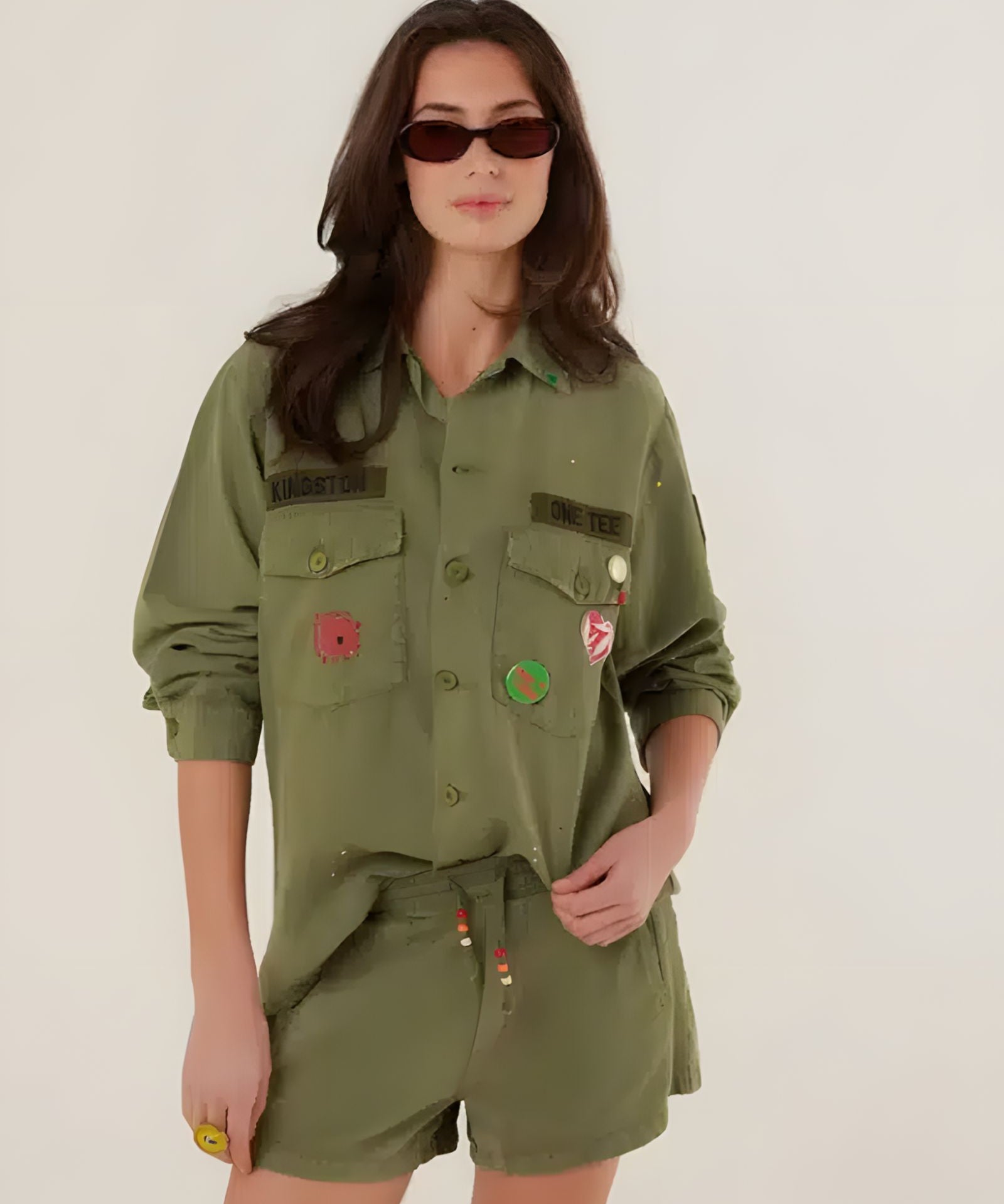 A woman wearing the high-waisted khaki Paul relaxed fit shorts, highlighting the wide-leg cut, side pockets, and bohemian beaded drawstring details.