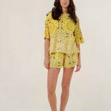 Full-length front view of a model wearing the oversized yellow bandana print Henry T-shirt featuring a mineral dye gradient, paired with matching shorts.
