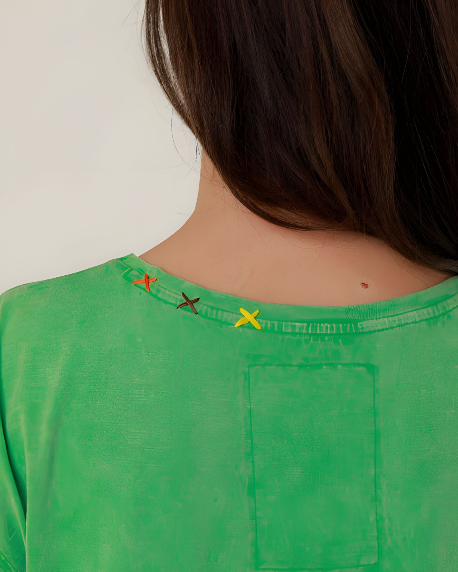 Close-up rear view of the green Molly t-shirt neckline, showcasing the subtle yellow signature OT embroidered details.