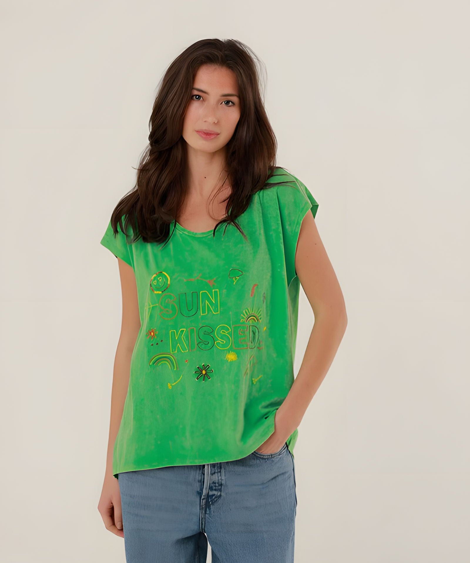 Close-up front view of a model wearing the vibrant green cotton Molly T-shirt with multicolored SUN KISSED chest embroidery.